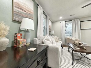 A modern living room with a sofa, a coffee table, and a lamp.