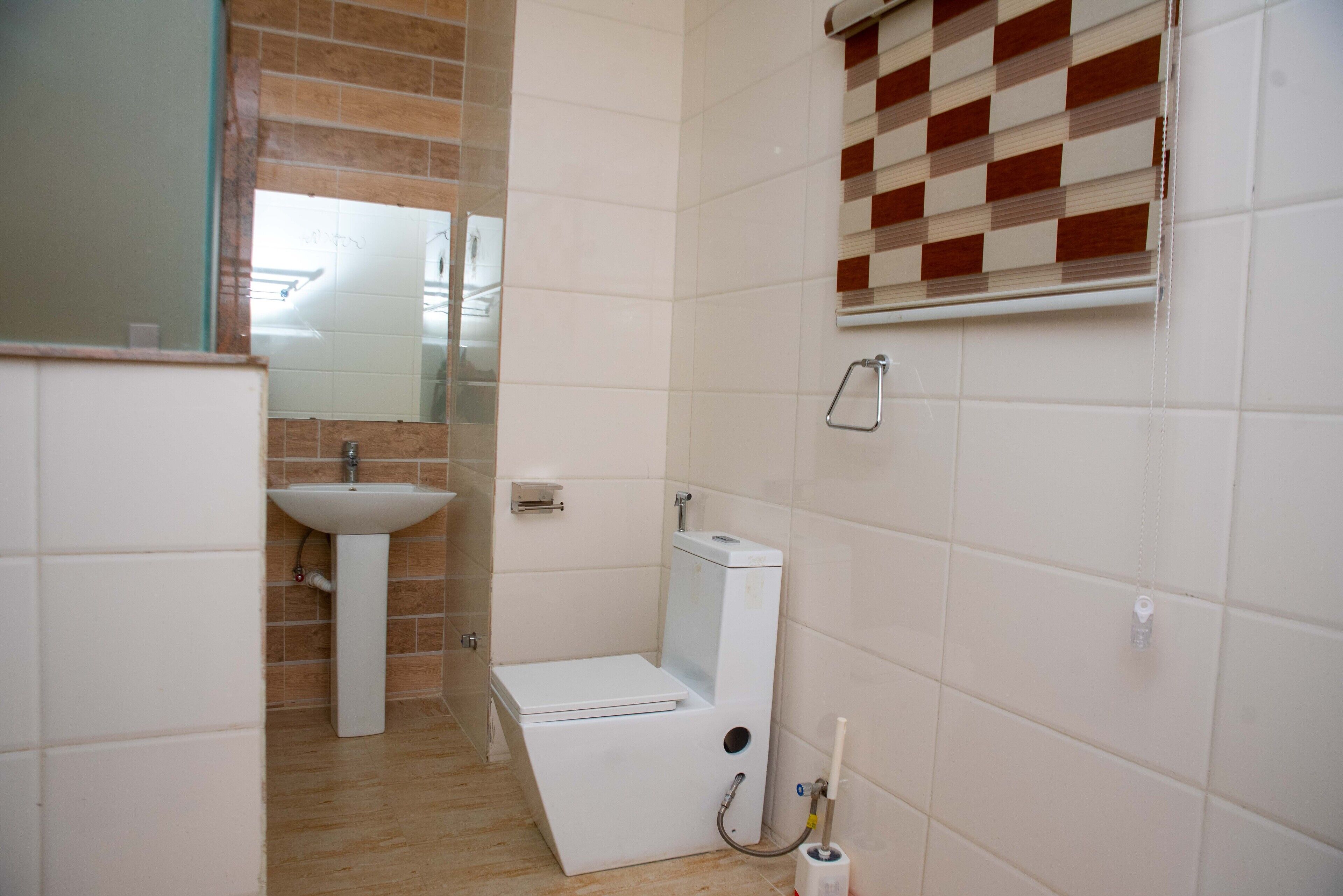 A bathroom with a sink, toilet, and mirror.