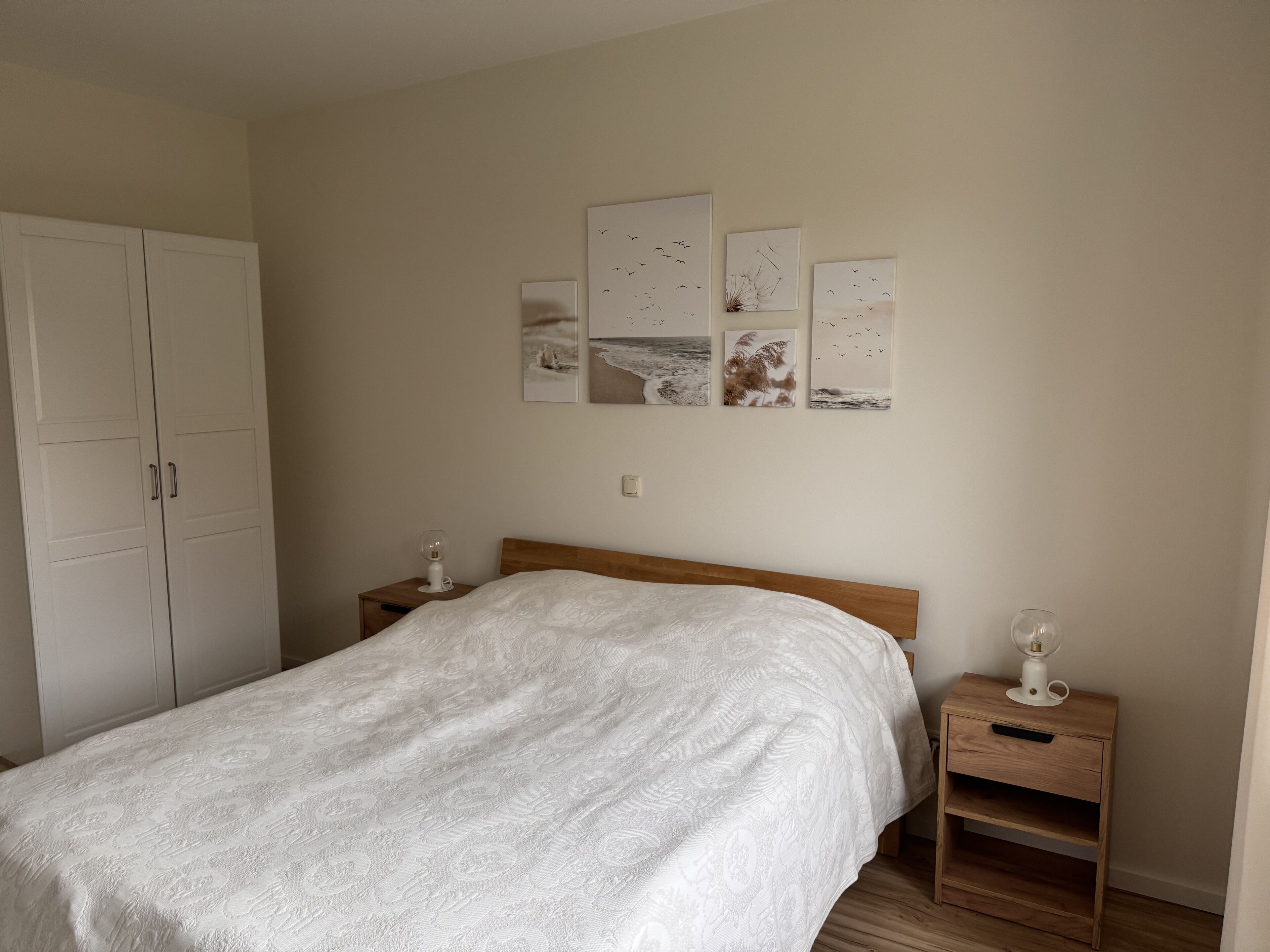 Ein Schlafzimmer mit einem Bett, einem Kleiderschrank und einem Nachttisch mit Lampe.