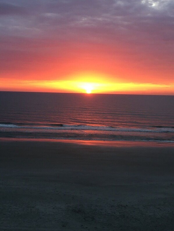 A sunset over a beach with waves.