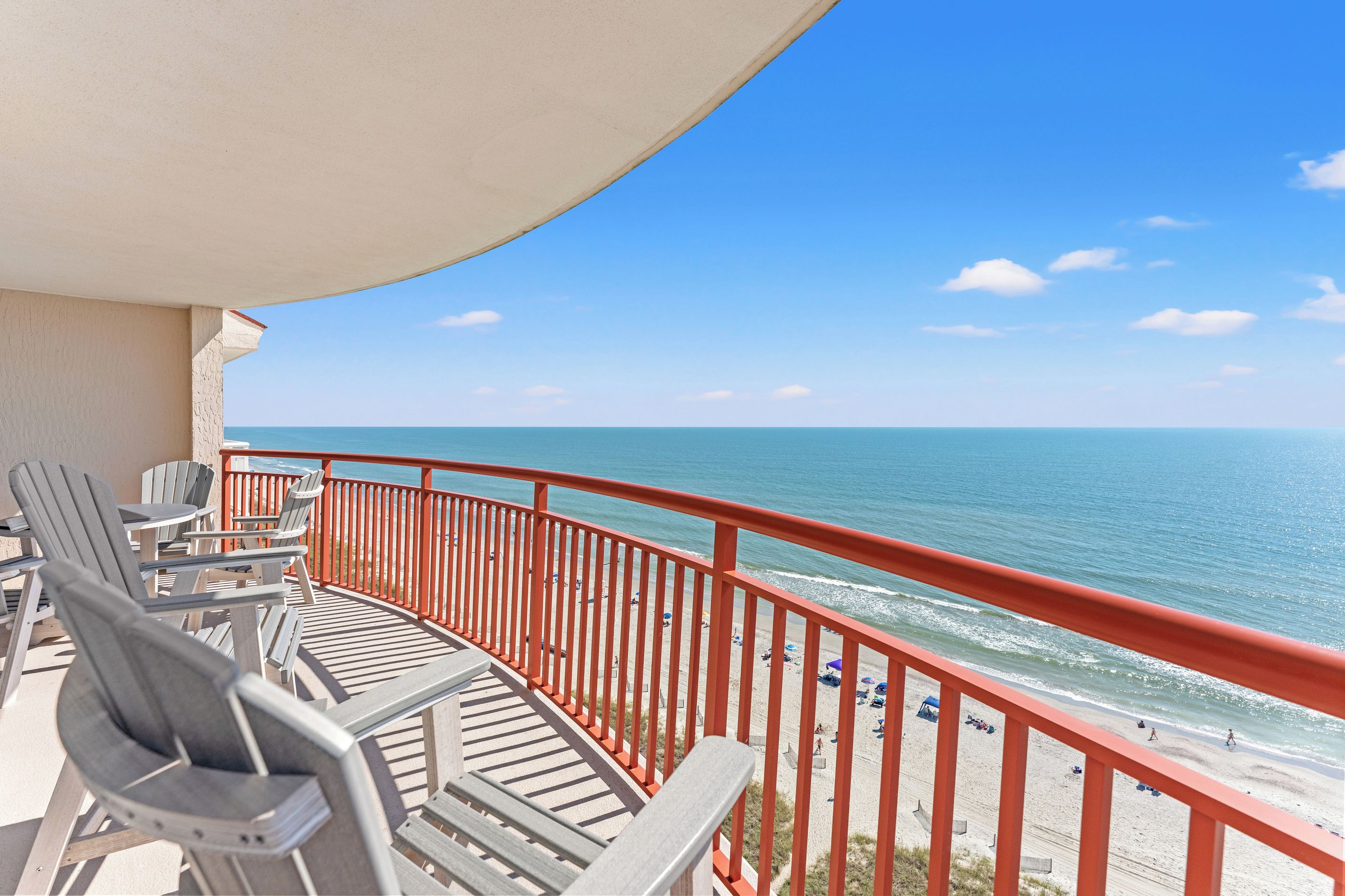 A balcony with a view of the beach and ocean.