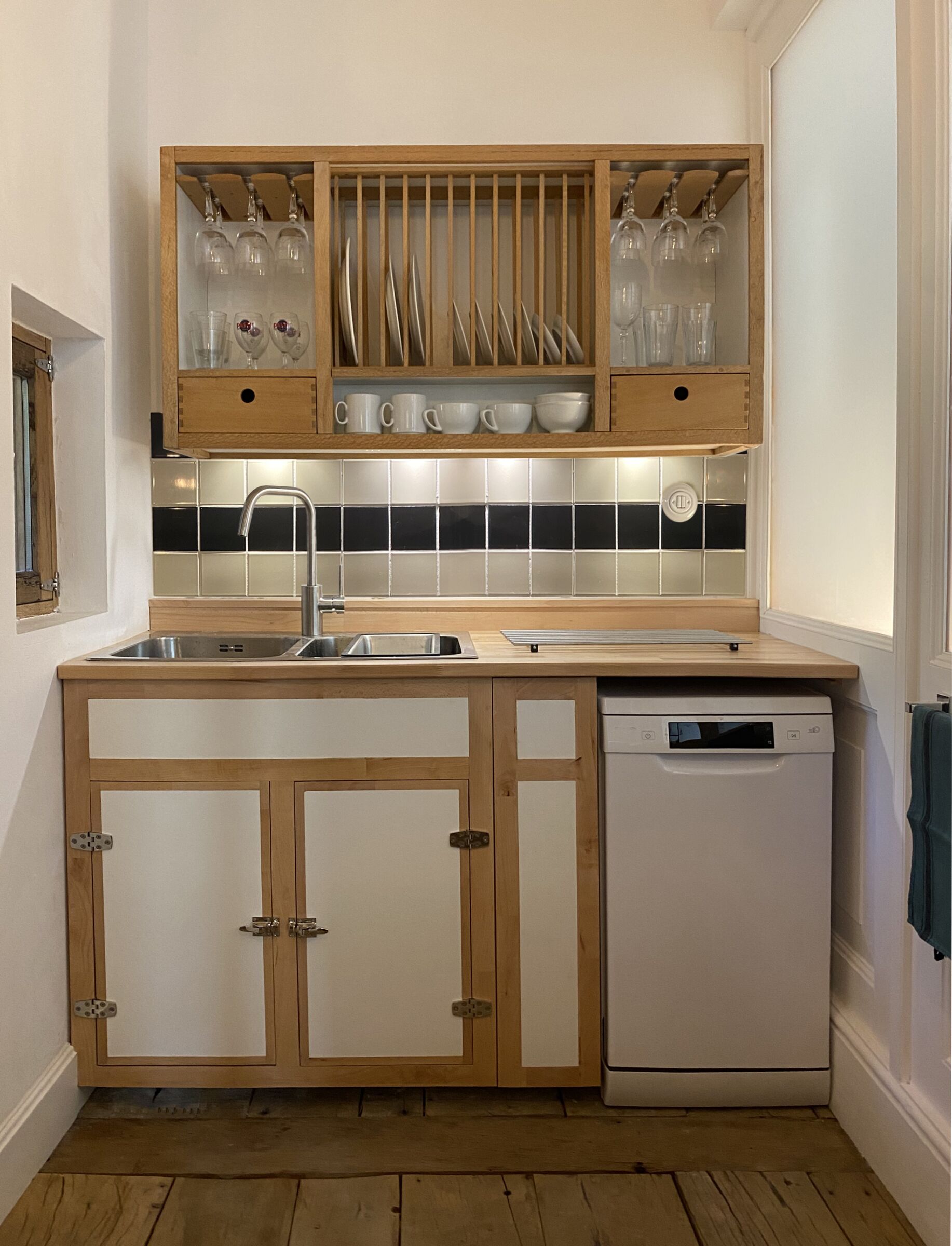 A kitchen with wooden cabinets, a dishwasher, and a tiled backsplash.