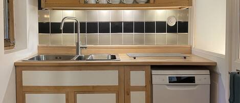 A kitchen with wooden cabinets, a dishwasher, and a tiled backsplash.