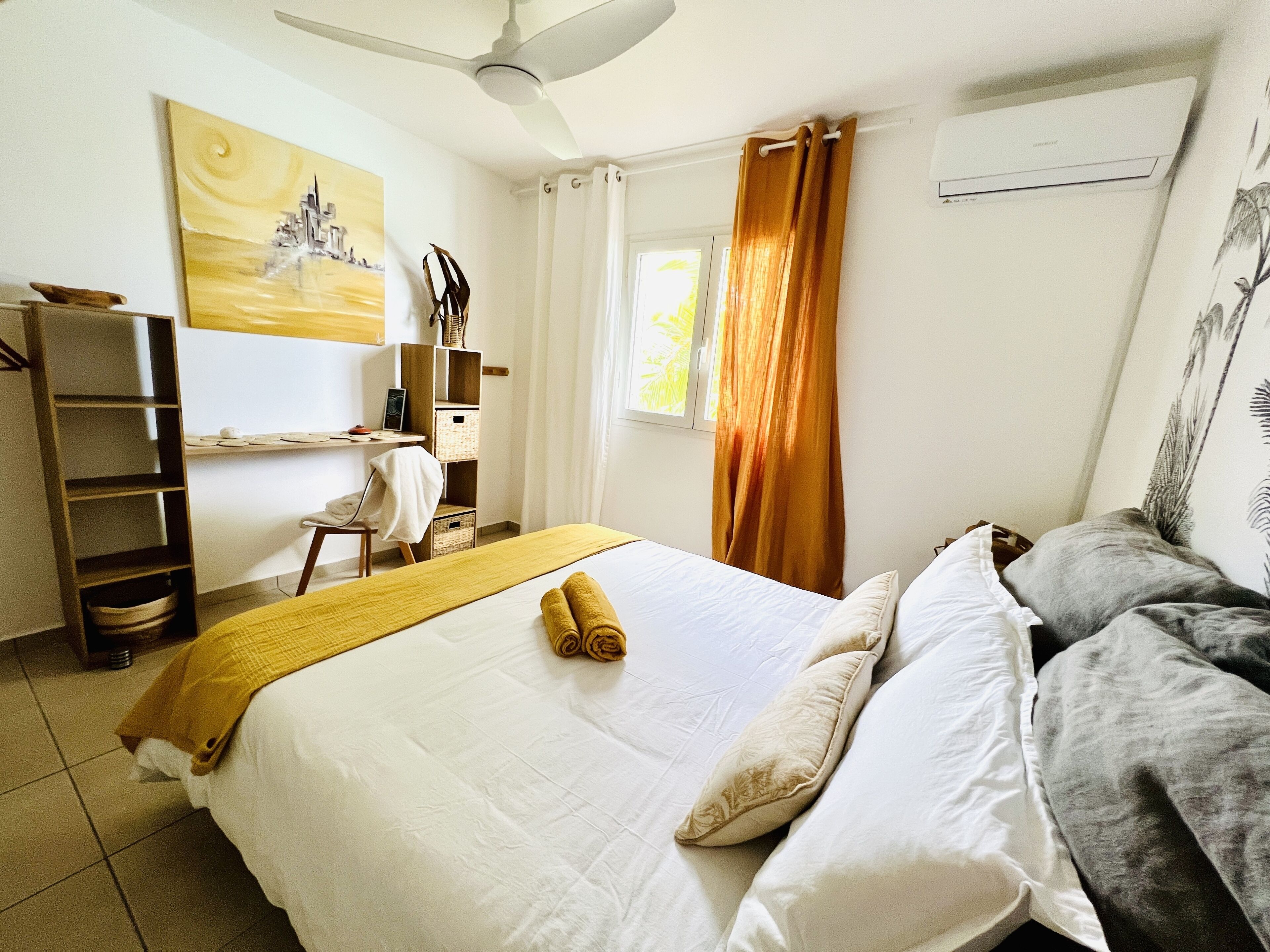 A bedroom with a bed, a desk, a chair, a wardrobe, and a window with curtains.