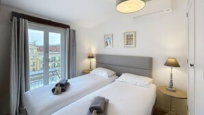 A hotel room with two beds, a balcony, and a city view. - 2 bedrooms with terrace 1 minute from the Palais Cannes Croisette Apartment (Cannes)