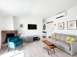 A modern living room with a fireplace, a sofa, a coffee table, and a TV. - 2 bedrooms with terrace 1 minute from the Palais Cannes Croisette Apartment (Cannes)