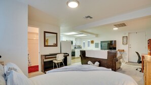 A hotel room with a bed, a desk, a chair, a kitchenette, and a bathroom. - Tucson Studio ~ 2 Mi to University of Arizona! (Tucson)