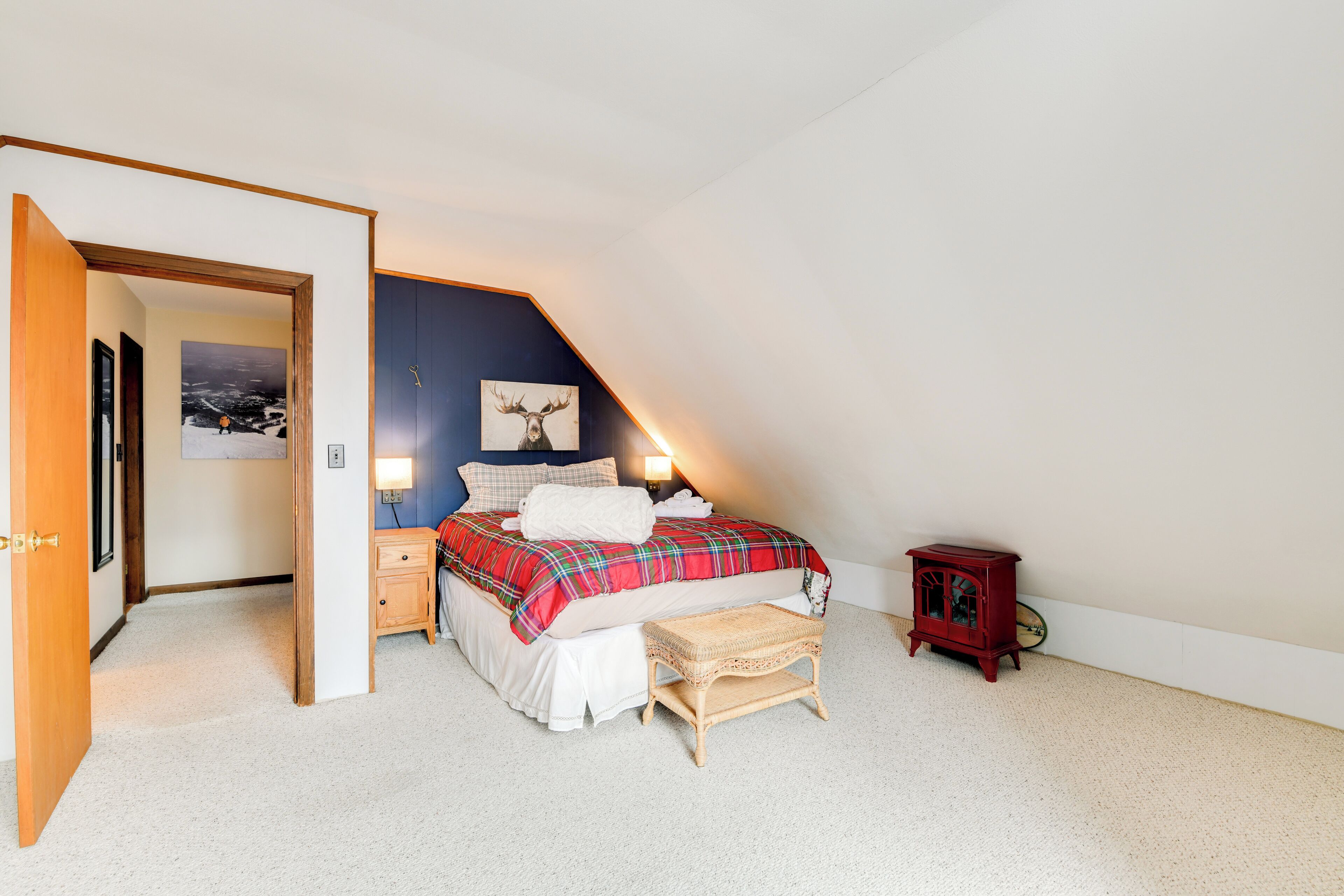 Une chambre à coucher comprenant un lit, une table de chevet, une petite table et une étagère fixée au mur.