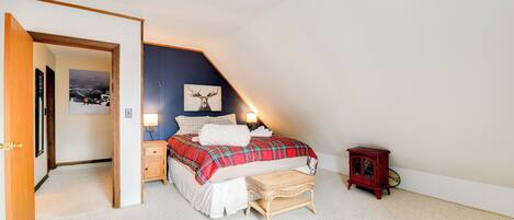 Une chambre à coucher comprenant un lit, une table de chevet, une petite table et une étagère fixée au mur.