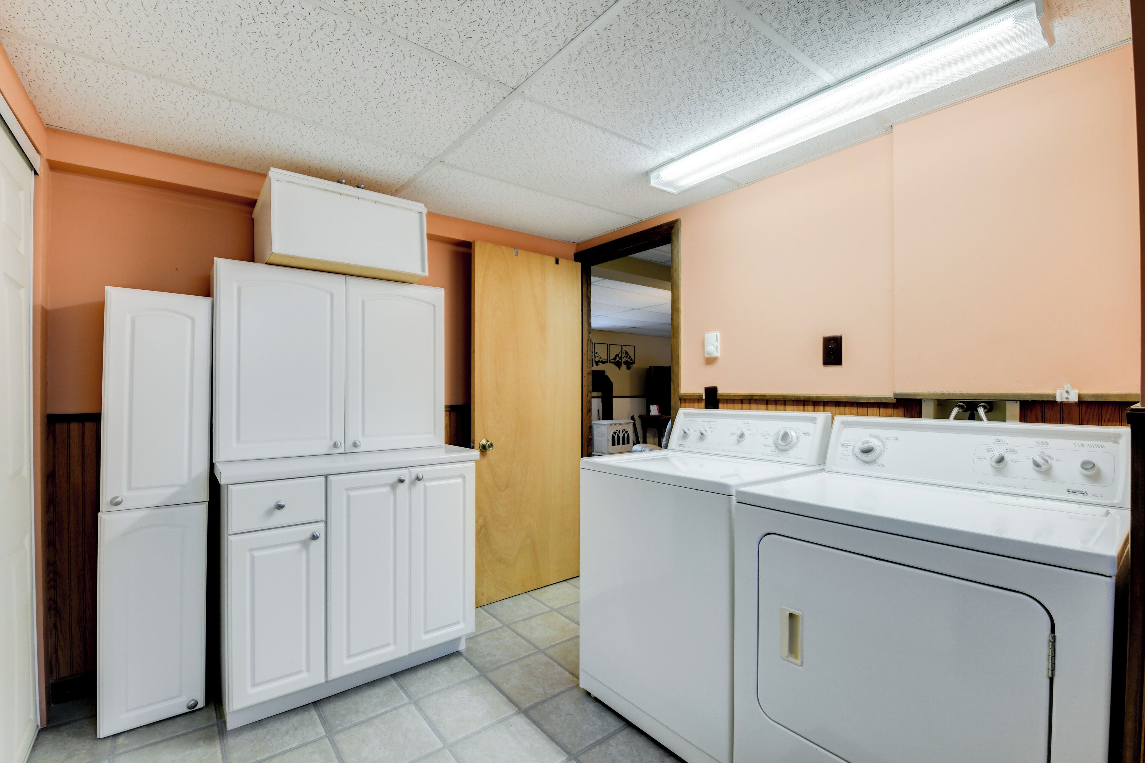 A laundry room with stacked cabinets and a front-loading washer and dryer.