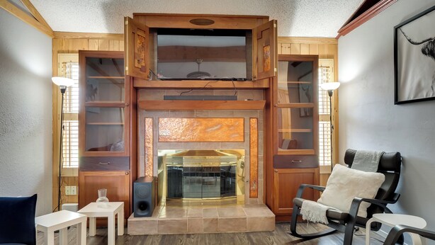 A cozy living room with a fireplace, wooden shelving, and comfortable seating. - Round Rock Home With Large Yard: 20 Mi to Austin! (Round Rock)