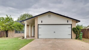 A single-story house with a garage, a covered porch, and a lawn. - Round Rock Home With Large Yard: 20 Mi to Austin! (Round Rock)