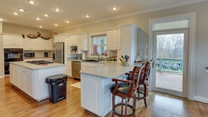 A spacious kitchen with white cabinets, a large island, and a view to the outside. - 6 Mi to Bourbon Trail: Group Estate on 20 Acres (Shelbyville)