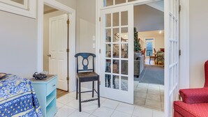 A room with a bed, a chair, a dresser, and a door leading to a dining area with a Christmas tree. - 6 Mi to Bourbon Trail: Group Estate on 20 Acres (Shelbyville)
