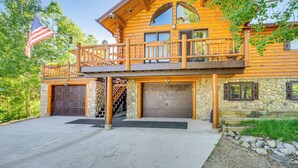 Eine Blockhütte mit Steinunterbau, einem Holzbalkon und einer Garage.
