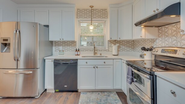 A modern kitchen with white cabinetry, stainless steel appliances, a dishwasher, and a patterned backsplash. - North Charleston Escape ~ 15 Mi to Dtwn Charleston (North Charleston)