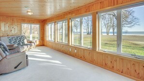 Una habitación amplia con paredes de madera y ventanas grandes que ofrecen vistas al exterior.