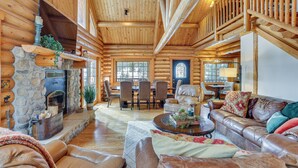 A log cabin interior with a stone fireplace, leather furniture, and a dining area. - 4 Mi to Rocky Mtn Nat'l Park: Cabin Near Town! (Grand Lake)