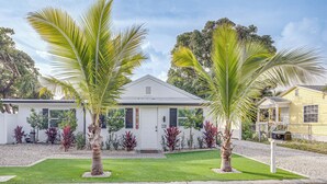 A two-story house with a white exterior, a front porch, and a well-maintained lawn. - Heated Pool + Backyard: North Palm Beach Retreat! (Juno Beach)
