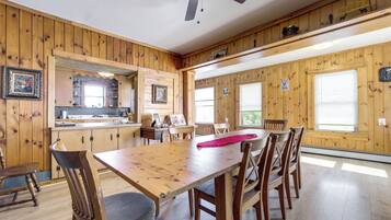 Interior de madera con una mesa de comedor, sillas y un ventilador de techo.