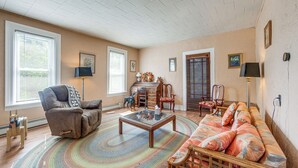 A spacious living room with a sofa, armchairs, a coffee table, and a fireplace. - Altmar Vacation Rental ~ 4 Mi to Salmon River! (Parish)