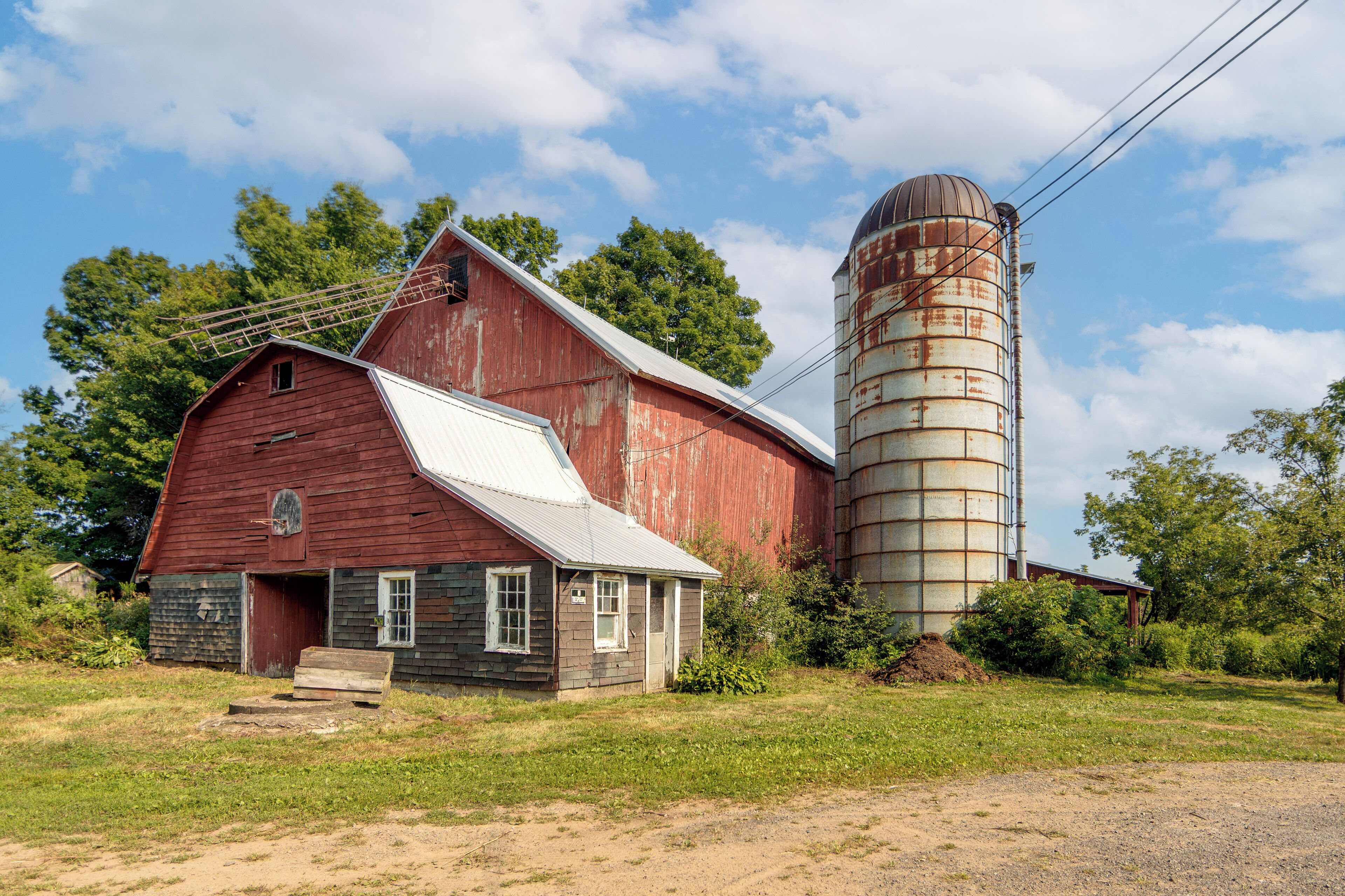 A red barn with a silo attached to it.