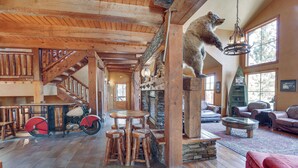 A rustic interior with a wooden staircase, a bear sculpture, a motorcycle, and leather furniture. - Ride to Sturgis! Lead Home w/ Pool Access (Lead)
