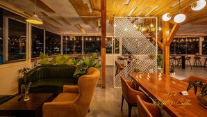 A modern interior with a wooden ceiling, large windows, a staircase, and seating areas. - Hera Boutique Hotel (Xuan Huong - Da Lat)