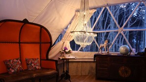 A cozy interior with a wooden bench, a chandelier, a globe, and a window with a view of trees. - villa Fukuza (Naganuma)