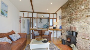 Una sala de estar acogedora con chimenea, un sofá, una mesa de centro y una estatua de un perro.