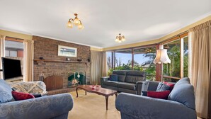 Ein Wohnzimmer mit Kamin, zwei Sofas, einem Couchtisch und einem Fernseher.