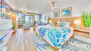 A spacious bedroom with a large bed, a ceiling fan, and a view of the ocean through the sliding glass door. - Amazing Direct Modern 2nd Floor Oceanfront w Fireplace (Myrtle Beach)