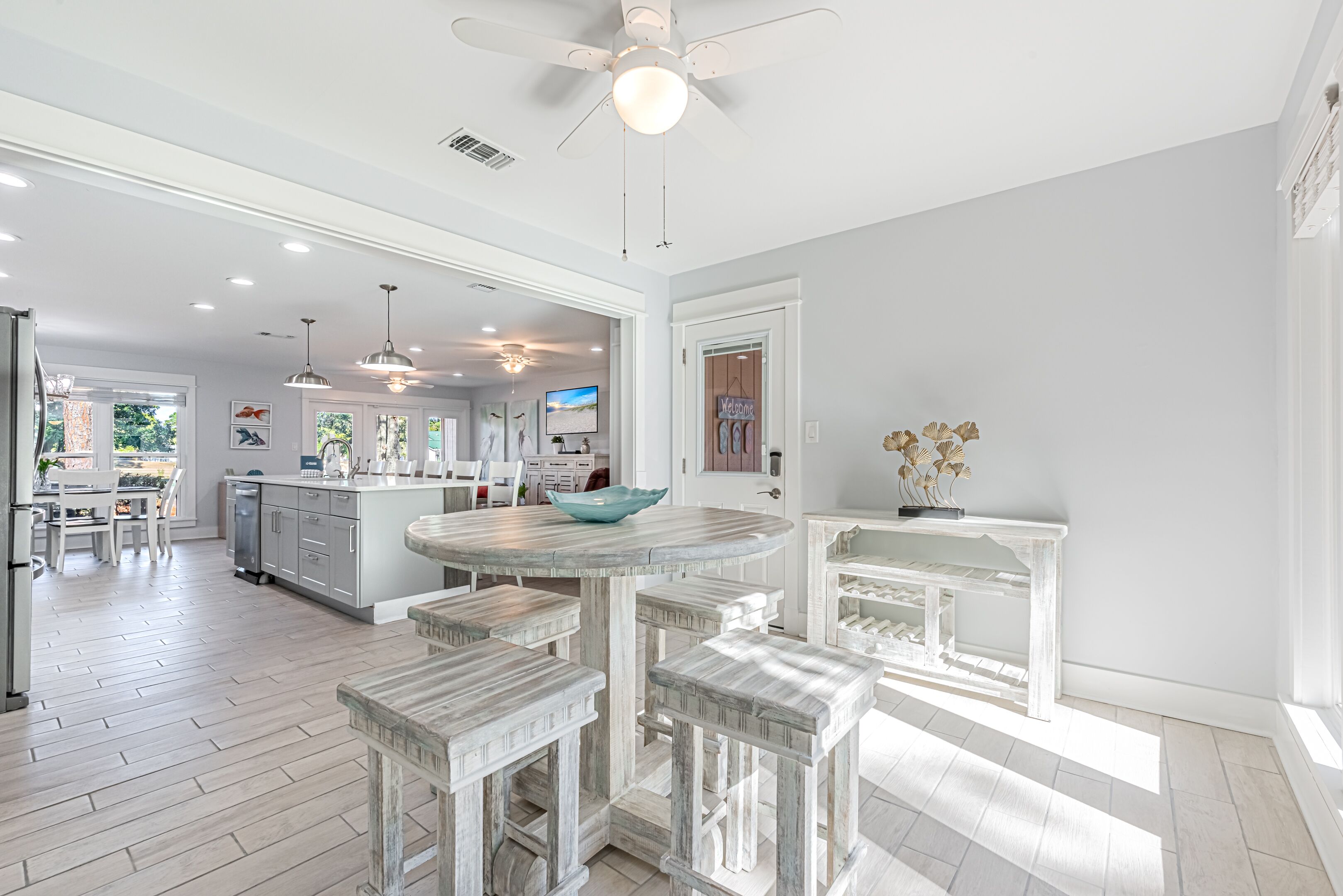 A spacious kitchen with a central island, bar stools, and pendant lighting.