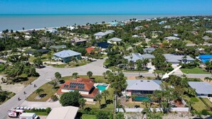 An aerial view of a coastal residential area with houses, roads, and a beach. - Sooner Beach Escape: Cute Pool Home in East Rocks (Sanibel)