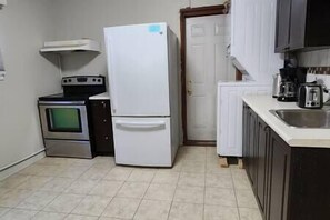 Une petite cuisine équipée d’un réfrigérateur, d’une cuisinière, d’un four et d’un évier.