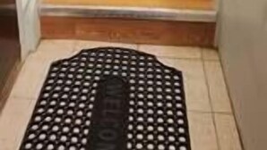 A wooden staircase with a black mat at the bottom. - Chesskings Guest House - Unit 2 Notredame Avenue (Winnipeg)