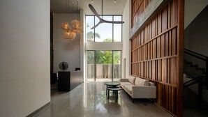 A spacious, modern interior with a high ceiling, large windows, and a mix of natural and artificial lighting. - Taprobane House (Colombo)