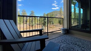 A balcony with a view of a forest and mountains.