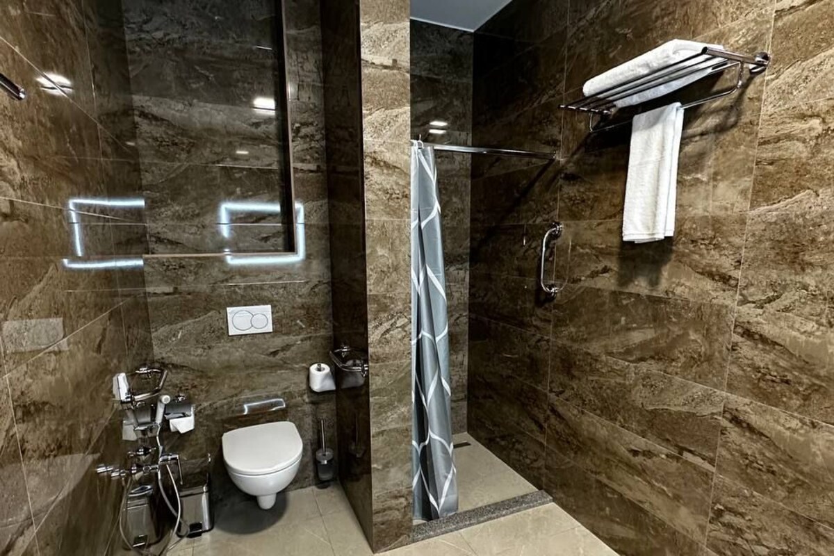 Une salle de bain moderne avec une douche à parois de verre, des toilettes et un lavabo.
