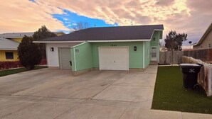 A two-story house with a green exterior and a garage.