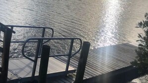 Un muelle de madera se adentra en un lago tranquilo bajo un cielo despejado.