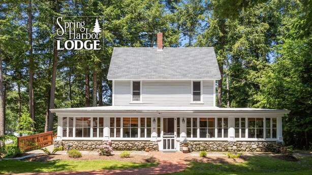 A two-story lodge with a stone foundation and a covered front porch. - Vintage & Modern Lodge-Lake Winnipesaukee water access w/ boat slip, dog welcome (Gilford)