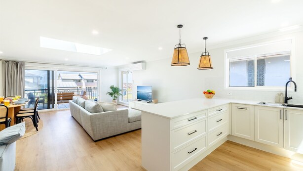 A modern apartment with a kitchen, dining area, and a balcony. - Bel Air, 8A Ocean Ave - pet friendly, water views and air con (Anna Bay)