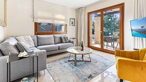 A modern living room with a grey sofa, a round coffee table, and a yellow armchair. - Villa HG21 Olympus - Two Bedroom Villa, Sleeps 4 (Kouklia)