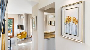 A modern hotel room with a dining area, a yellow armchair, and a framed artwork on the wall. - Villa HG21 Olympus - Two Bedroom Villa, Sleeps 4 (Kouklia)