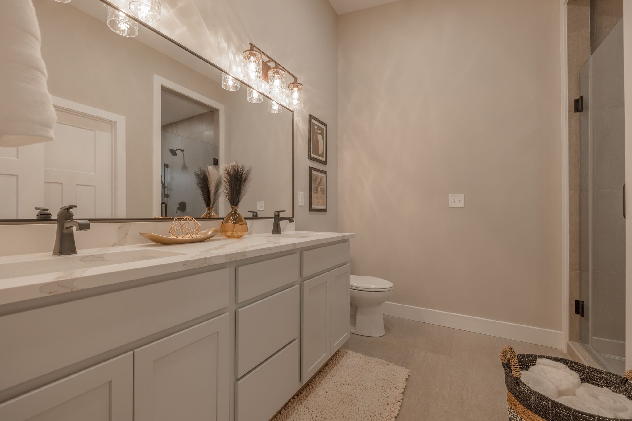 Un bagno moderno con uno specchio grande, un mobile lavabo e una zona doccia.