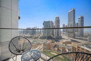 A balcony with a city view, featuring modern buildings and a clear sky.
