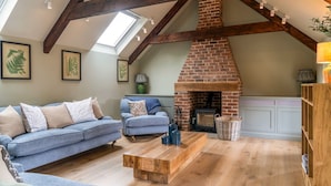 A loft-style living room with exposed wooden beams, a brick fireplace, and a skylight. - Little Hideaway - Four Bedroom Villa, Sleeps 8 (Whitelackington)
