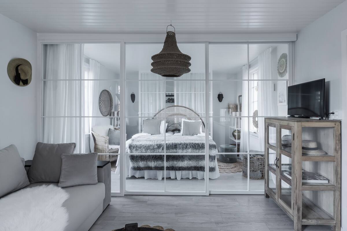 Ein modernes Schlafzimmer mit einem großen Bett, einem Fernseher und einem Kleiderschrank.