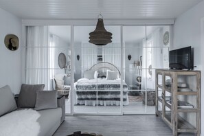 A modern bedroom with a large bed, a television, and a wardrobe. - Pensionat Enehall (Bastad)